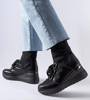 Person wearing Rochon Black Platform Buskin Boots with jeans, featuring a sleek design and 6 cm platform heel for style and comfort.