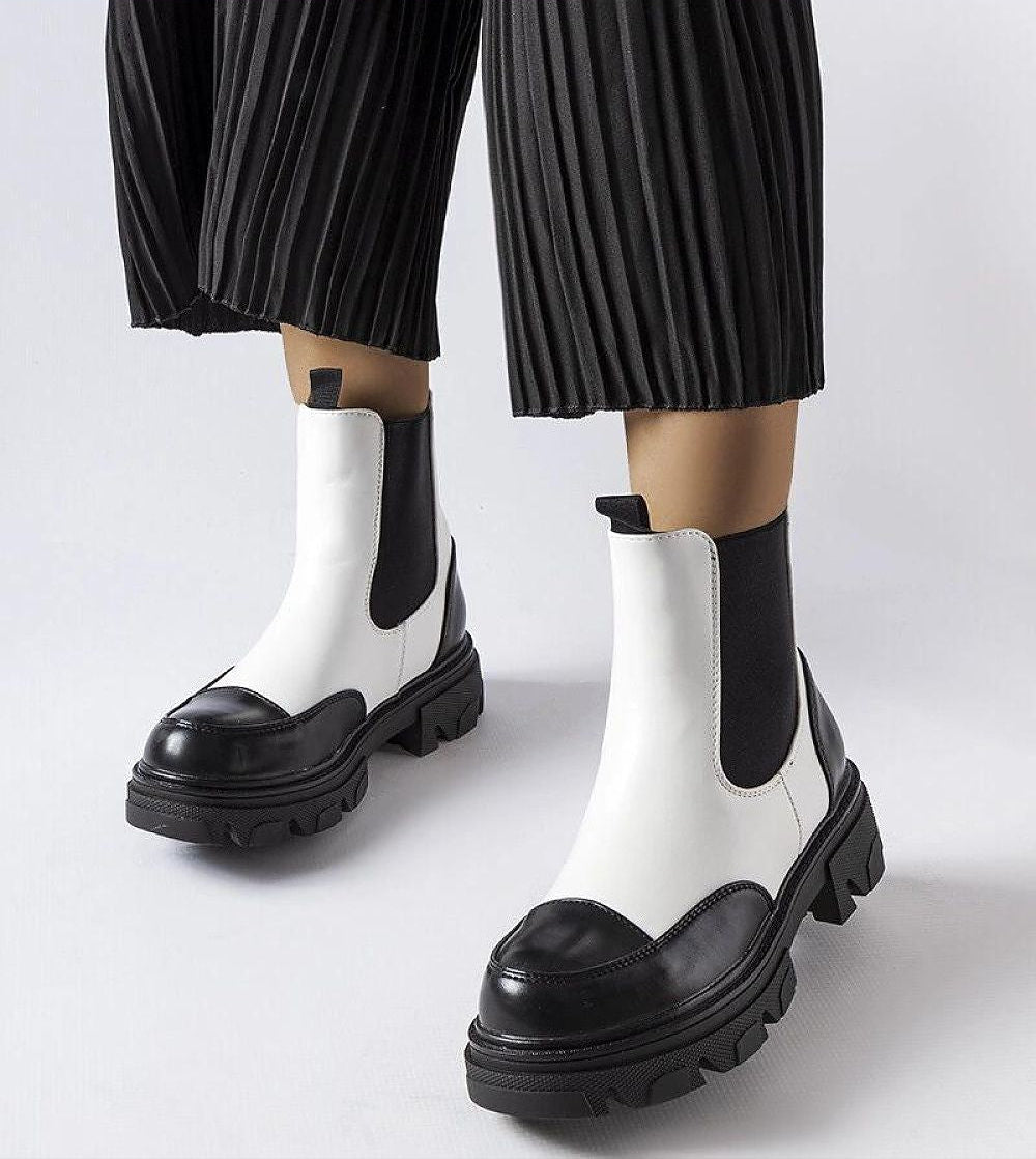 Albany Two-Tone Rubber Platform Boots in black and beige worn with pleated pants, showcasing their minimalist and elegant design.