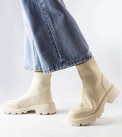 Woman wearing Lonte stretch-knit beige sock boots with jeans, showcasing elegant and comfortable style with medium heel and rounded toe.