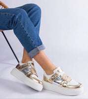 Person wearing Olyssia Layered Shine Lace Sneakers in gold with eco leather, 4 cm rubber sole, against a neutral background.