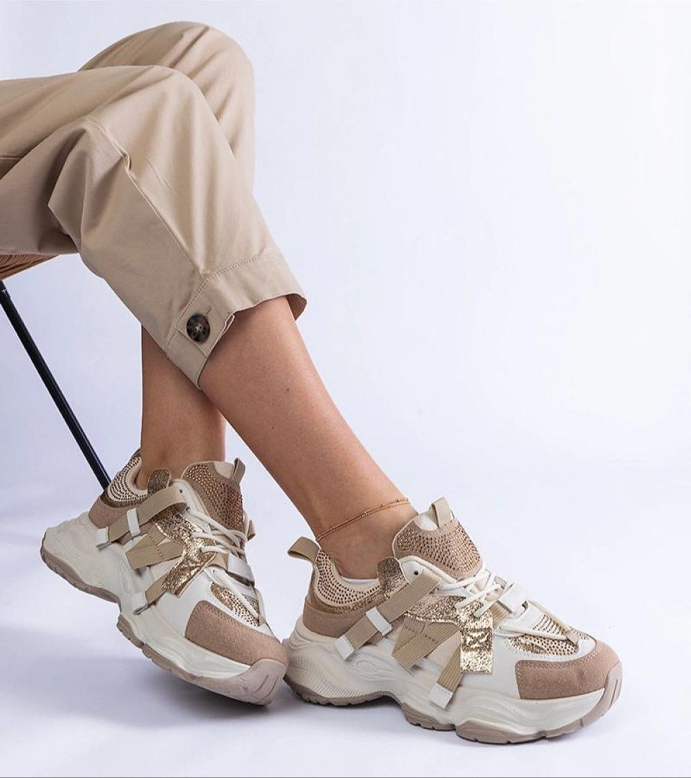 Avessia Elevated Suede Accent Sneakers with sculpted sole and shimmering inserts, styled with beige pants for a casual look.