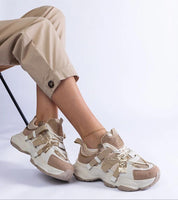 Avessia Elevated Suede Accent Sneakers with sculpted sole and shimmering inserts, styled with beige pants for a casual look.