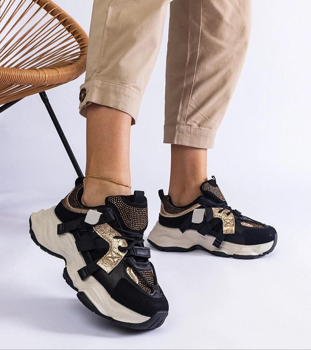 Woman wearing Avessia Elevated Suede Accent Sneakers with shimmering inserts and 6 cm platform, paired with beige pants.