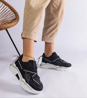 Person wearing Nimvara Shimmer Detail Black Sneakers with white soles, showcasing modern design and eco leather finish.