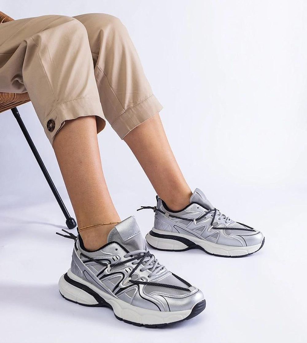 Person wearing Yndessa Sculpted Sole Lace Sneakers in silver, showcasing sleek low-cut style and sporty design for versatile fashion.