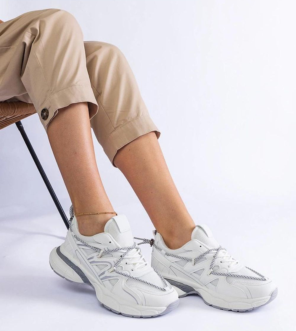 Yndessa Sculpted Sole Lace Sneakers in white eco leather, showcasing a sleek low-cut design on a person wearing beige pants.