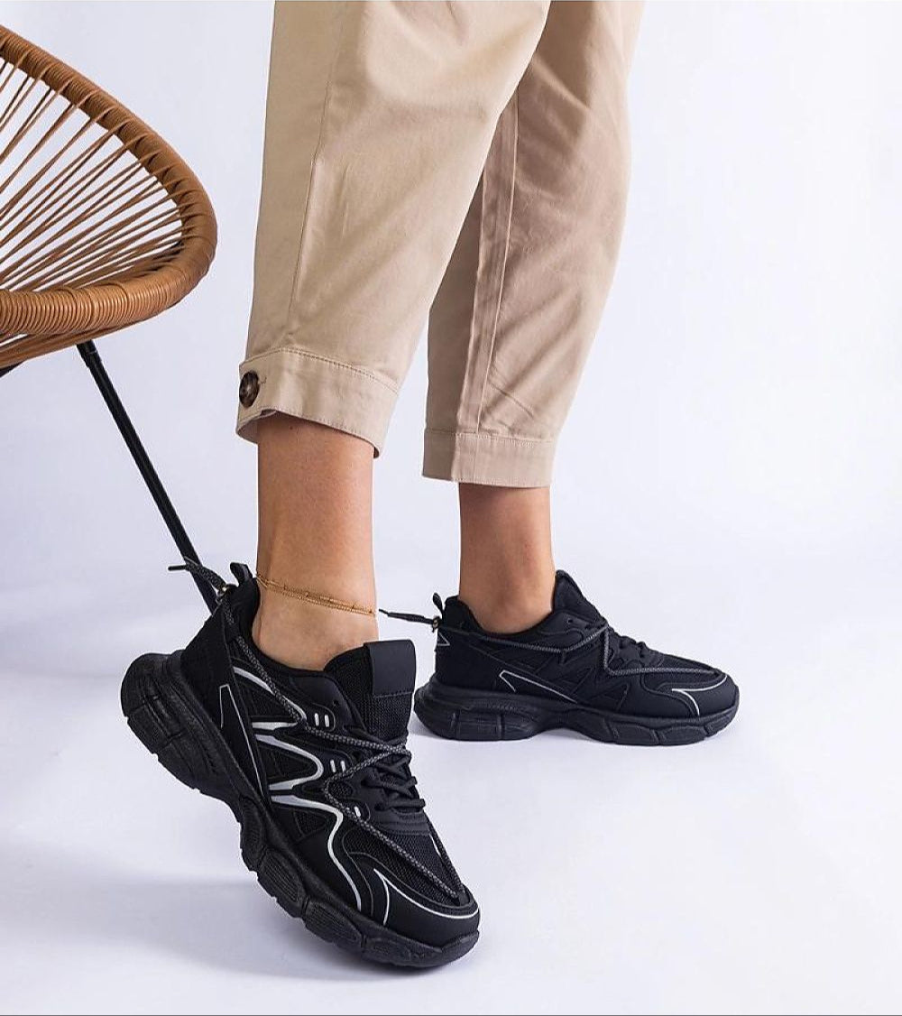 Person wearing Yndessa Sculpted Sole Lace Sneakers in black, showcasing sleek low-cut design and sculpted sole for modern comfort.