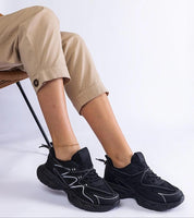 Woman wearing Yndessa Sculpted Sole Lace Sneakers in black, showcasing sleek low-cut design and sporty, modern comfort.