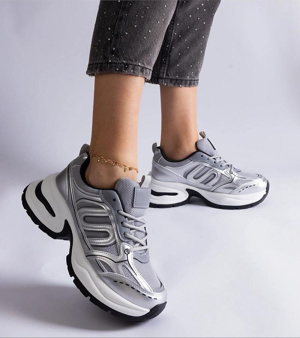 Lunvera Metallic Sport Style Sneakers with silver upper and black sole, worn with jeans, showcasing athletic design and eco leather.