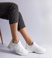 Woman wearing Melvyna White Motion Sneakers with eco leather upper and flexible sole, featuring low-cut lace-up design for comfort and style.