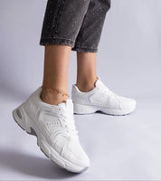 Melvyna White Motion Sneakers in eco leather with flexible gray sole, showcasing low-cut design and lace-up front for comfort and style.