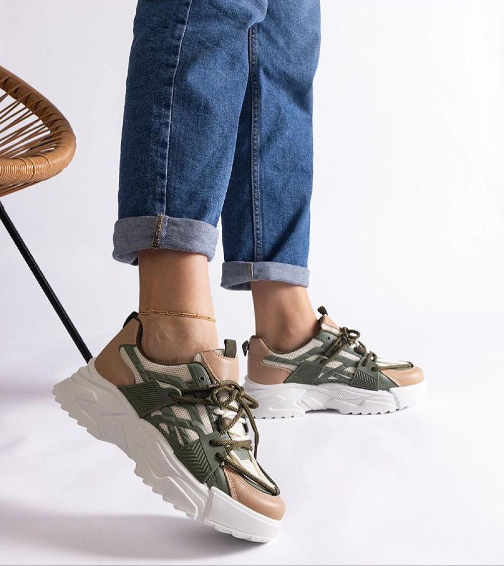 Woman wearing Orlira Sage-Toned Urban Sneakers with sculpted sole and lace-up style, showcasing green and beige tones for a trendy look.