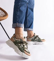 Woman wearing Orlira Sage-Toned Urban Sneakers with sculpted sole and lace-up style, showcasing green and beige tones for a trendy look.