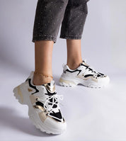 Woman wearing Selvyna Contrast Sport Sneakers in black-and-white with eco leather upper, showcasing the 5 cm supportive sole and lace-up design.