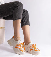 Person wearing Selvyna Contrast Sport Sneakers with orange accents, showcasing eco leather upper and supportive sole.