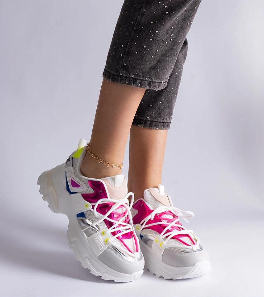 Woman wearing colorful sport sneakers with black jeans, showcasing trendy athletic footwear style.