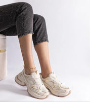 Woman wearing Elphira White Chunky Sole Sneakers with gray pants, showing eco leather upper and bold platform design.
