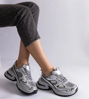 Person wearing metallic chunky sneakers with black sole, paired with cropped pants.