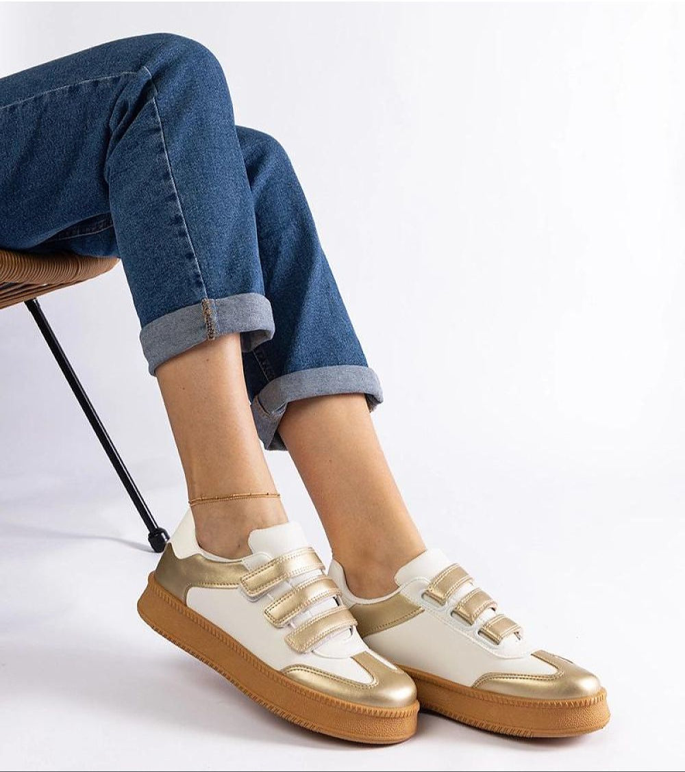 Person wearing Elurea Gold Velcro Street Sneakers with golden eco leather and brown rubber sole for elegant everyday style.