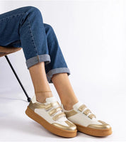 Person wearing Elurea Gold Velcro Street Sneakers with golden eco leather and brown rubber sole for elegant everyday style.