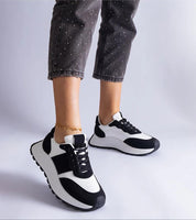 Black and white Veressa Minimal Platform Sneakers styled with ankle bracelet and cropped pants, showcasing modern design and versatility.