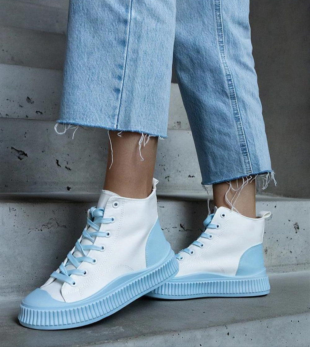Woman wearing Ossavine platform lace sneakers with blue accents, showcasing breathable textile upper and sculpted sole.