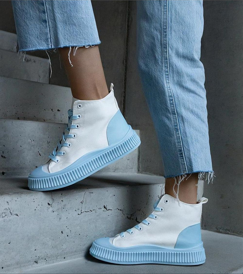 Person wearing Ossavine Fabric Platform Lace Sneakers with blue accents on stairs, showcasing their casual yet elevated design.
