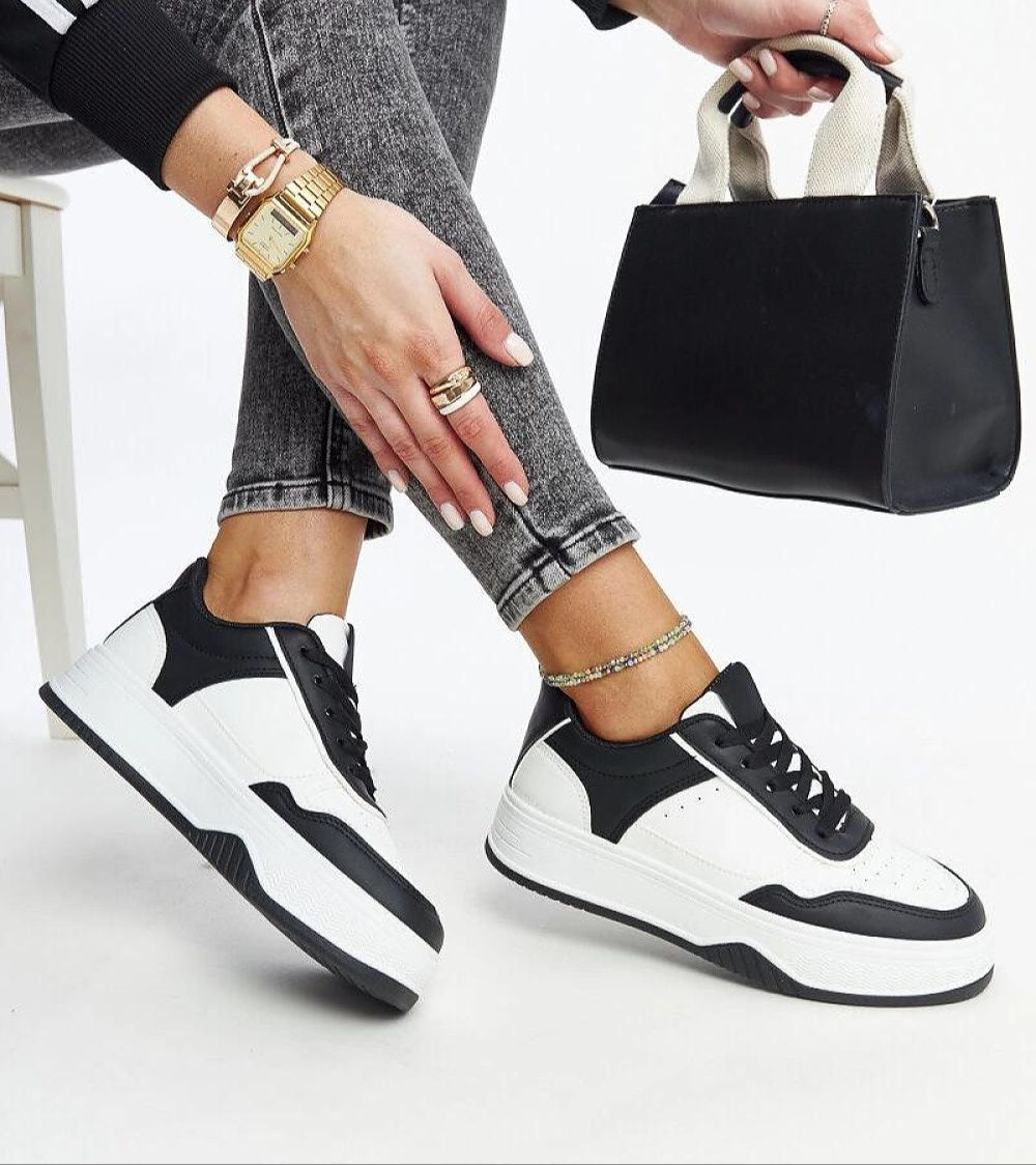 Person wearing Vartema platform sneakers in black and white eco suede leather with chunky sole, paired with stylish outfit and handbag.