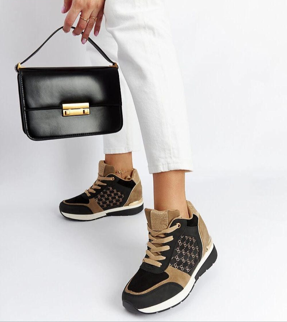 Woman wearing Lazetta black wedge sneakers with eco-leather and stylish 7.5 cm heels, paired with a black handbag.