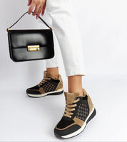 Woman wearing Lazetta black wedge sneakers with eco-leather and stylish 7.5 cm heels, paired with a black handbag.