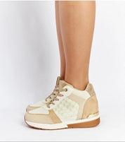 Side view of beige wedge sneakers with lace-up closure, featuring a stylish pattern and comfortable sole for casual wear.