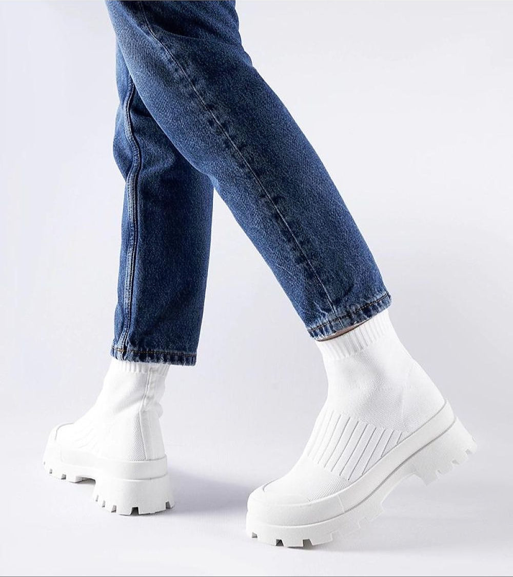 Person wearing Velvone slip-on platform sneakers in white with blue jeans for casual spring style.