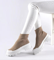 Model wearing Velvone Slip-On Platform Sneakers with flexible textile upper and white platform sole, styled with white pants.