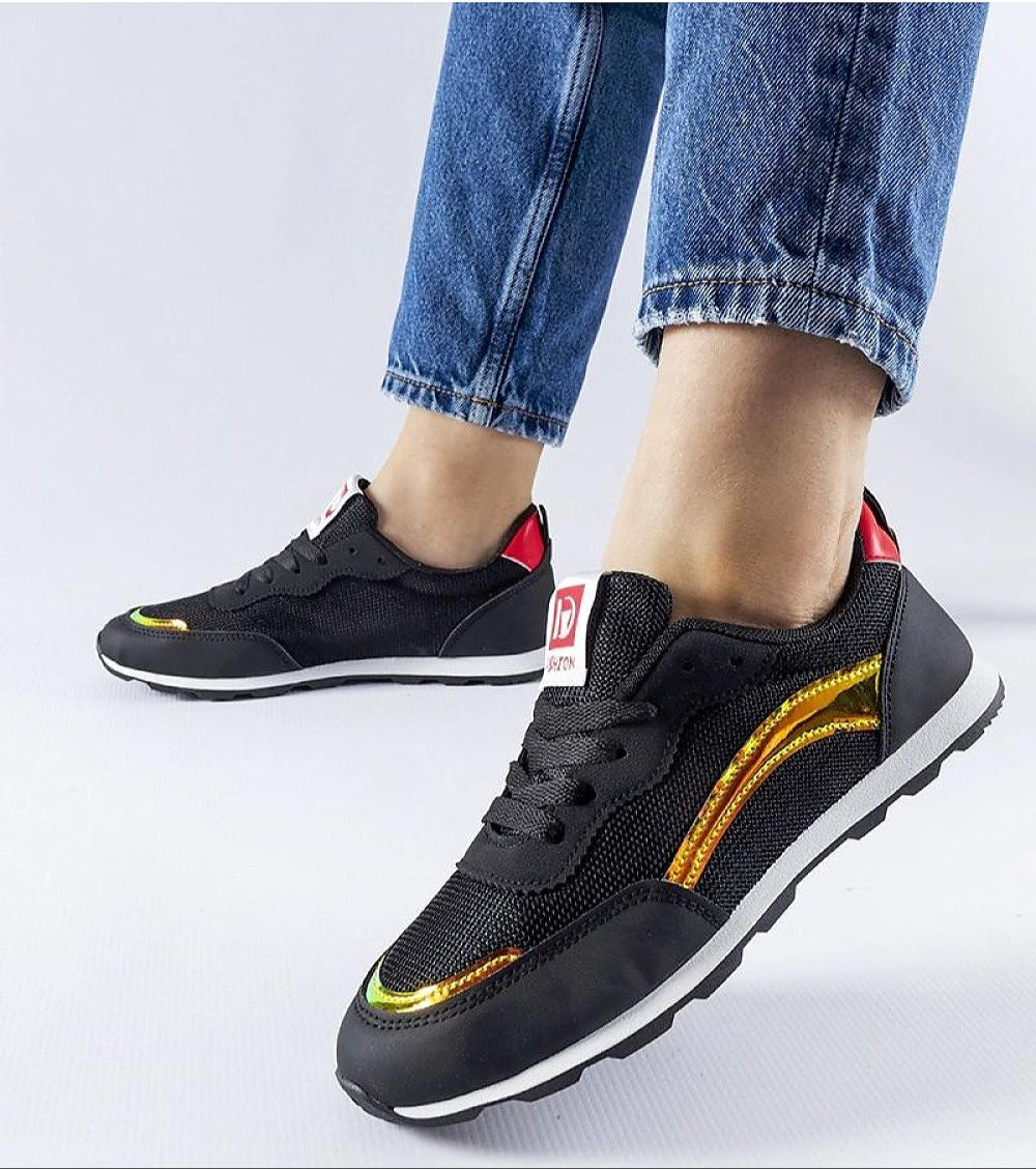 Black lightweight summer sneakers with iridescent detail, worn with cuffed jeans. Comfortable and stylish footwear ideal for casual outfits.