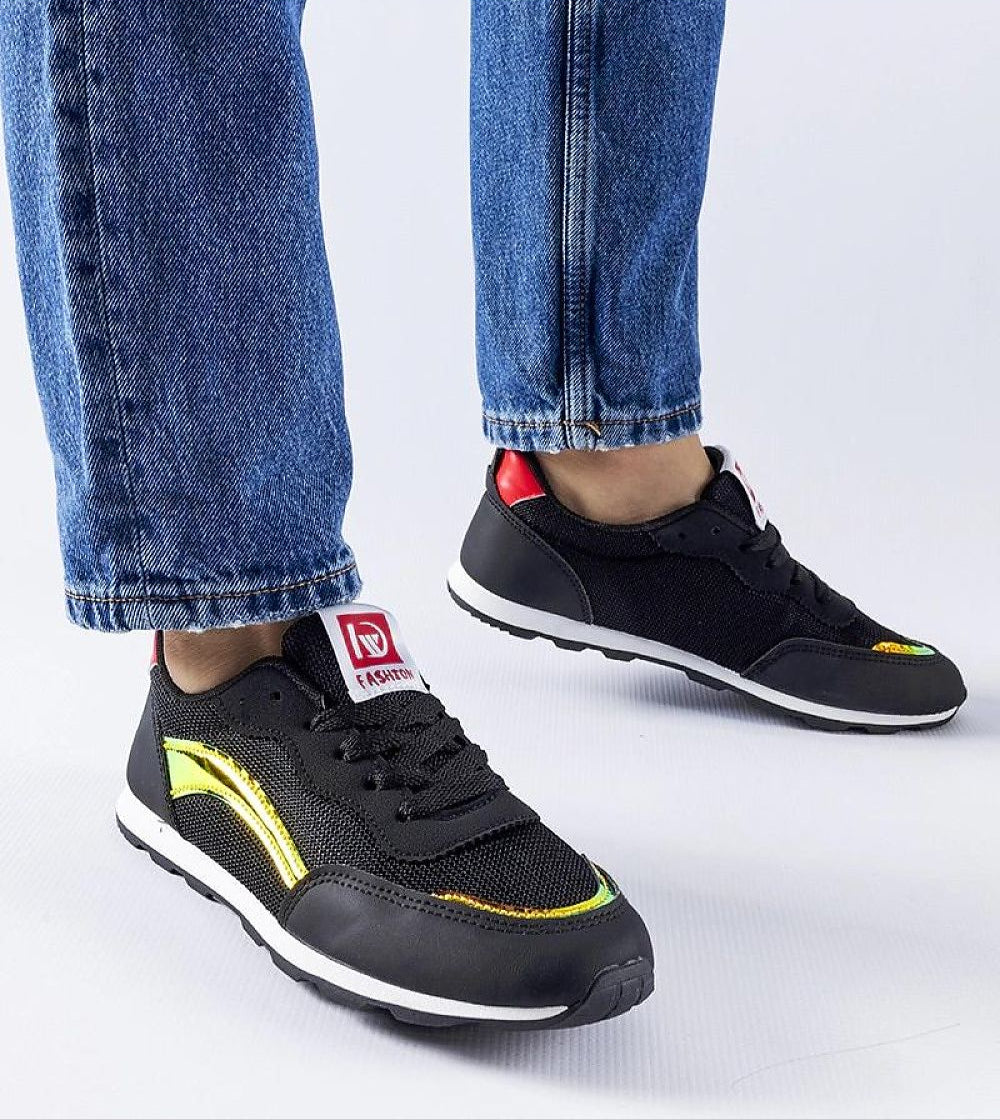 Person wearing Lirano Lightweight Summer Sneakers in black with jeans, showcasing breathable mesh design and sleek silhouette for casual style.