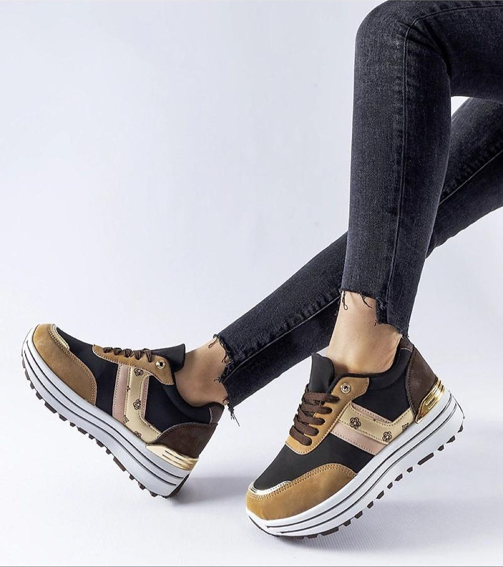 Brown Rovetta Suede Lace-Up Sneakers with platform sole paired with black jeans.