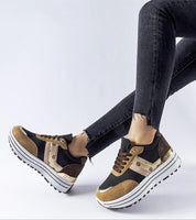 Brown Rovetta Suede Lace-Up Sneakers with platform sole paired with black jeans.