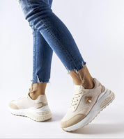 Casual outfit with beige and white sneakers, featuring a trendy gold charm on the side, paired with frayed hem jeans.
