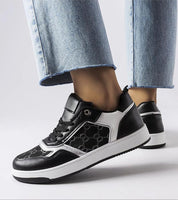 Stylish black and white monogram lace-up sneakers with flexible rubber sole, ideal for casual outings.