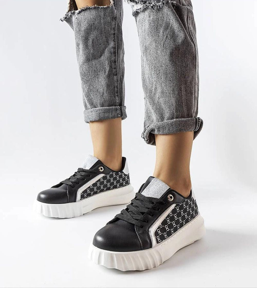 Person wearing Varello Urban Platform Sneakers in Black with eco-friendly synthetic leather and white rubber sole.