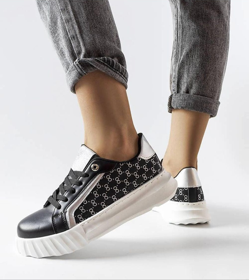 Person wearing Varello Urban Platform Sneakers in black, featuring black synthetic leather with a white rubber sole.