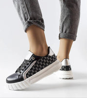 Person wearing Varello Urban Platform Sneakers in black, featuring black synthetic leather with a white rubber sole.