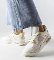 Person wearing Argena Beige Low-Top Summer Sneakers with blue jeans, featuring breathable materials and a crisp white rubber sole.