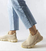 Person wearing Orellia Light Beige Slip-On Sneakers with blue jeans, showcasing breathable fabric and beige cushioned sole.