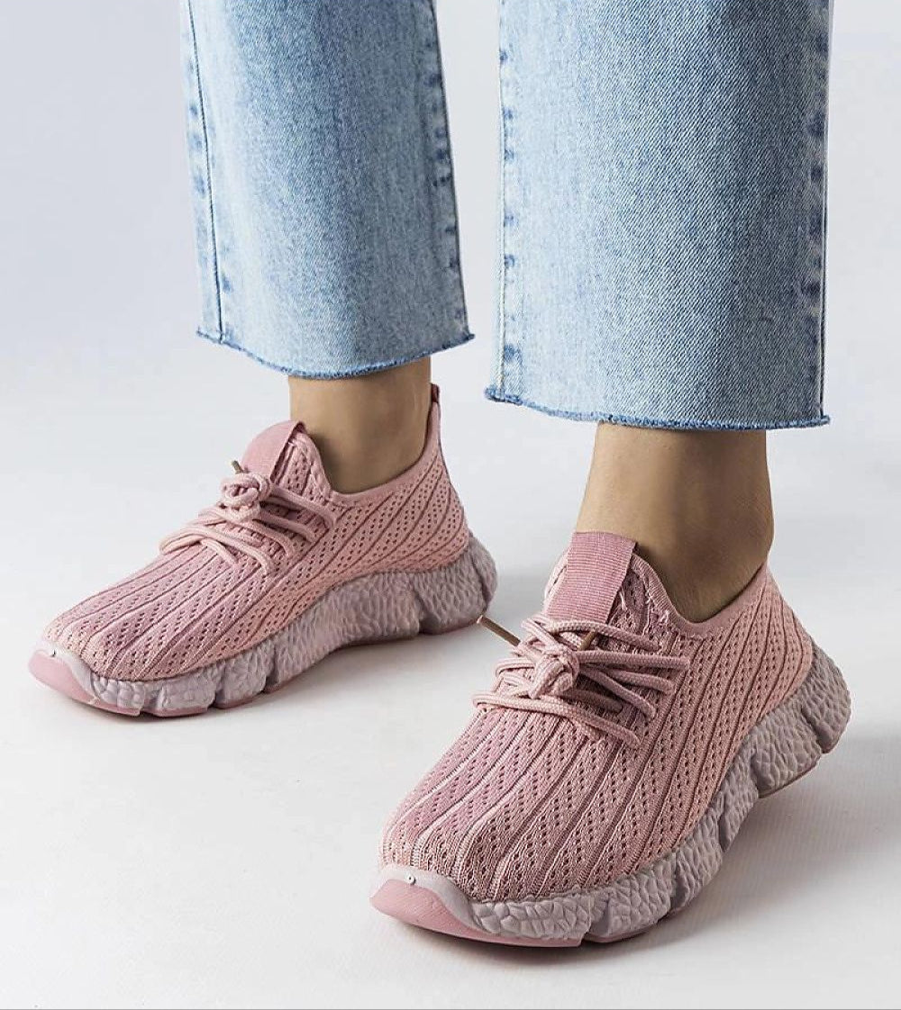 Woman wearing Elmera Pink Lightweight Sport Sneakers with lace-up design and breathable fabric, paired with blue jeans.