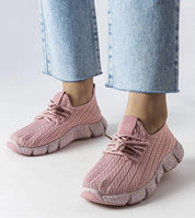 Woman wearing Elmera Pink Lightweight Sport Sneakers with lace-up design and breathable fabric, paired with blue jeans.