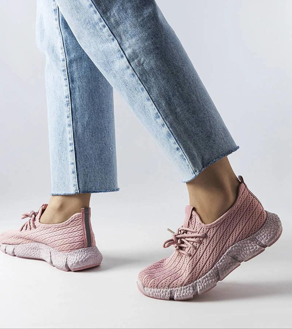 Person wearing Elmera pink lightweight sport sneakers with trendy design and breathable fabric, paired with jeans.