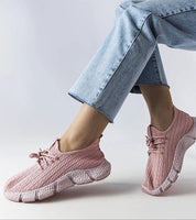 Woman wearing Elmera pink lightweight sport sneakers with blue jeans, showcasing breathable fabric and comfortable design.