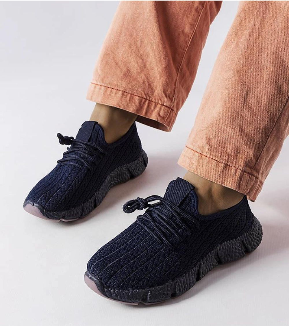 Person wearing Arvène Navy Summer Sport Sneakers with coral pants, showcasing breathable navy textile and 3 cm rubber sole design.