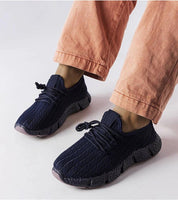 Person wearing Arvène Navy Summer Sport Sneakers with coral pants, showcasing breathable navy textile and 3 cm rubber sole design.
